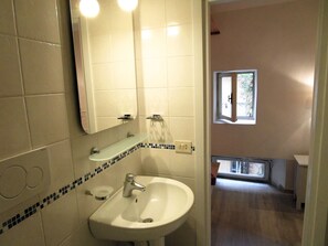 A bathroom with a sink, mirror, and a window. - A house in the heart of Rome, ideal to visit on foot. Comfort and calm area (roma)
