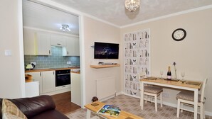A compact living space with a kitchenette, a dining area, and a seating area. - The Bridge Suite, Invermoriston - The Great Glenway (Invermoriston)