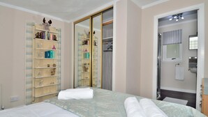 A bedroom with a bed, a wardrobe, and a bathroom visible through an open door. - The Bridge Suite, Invermoriston - The Great Glenway (Invermoriston)