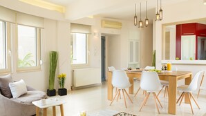 Un salon moderne avec un canapé, une table basse et un jeu d’échecs. Il y a également un coin repas avec une table et des chaises.