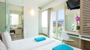 Une chambre d’hôtel avec deux lits, une salle de bain, un balcon avec vue et une télévision.
