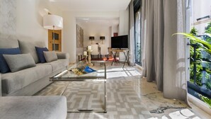 Ein modernes Wohnzimmer mit einer Couch, einem Couchtisch und einem Fernseher. Es gibt ein großes Fenster mit Vorhängen, eine Lampe und ein Gemälde an der Wand.
