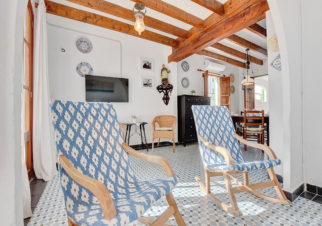A room with two rocking chairs, a television, and a dining area with a table and chairs.