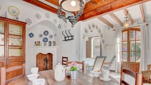 Un coin repas avec une table en bois, des chaises et une cheminée.