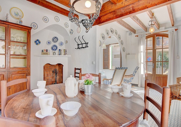 A dining area with a wooden table, chairs, and a fireplace.