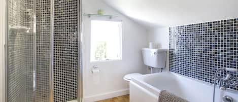 Bañera con ducha, secador de pelo, toallas, papel higiénico