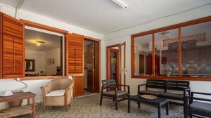 A room with a patterned floor, wooden furniture, and open doors leading to other areas.