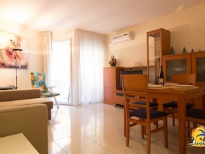 Relax in this stylish living room with a comfortable sofa, dining table, and large window.
