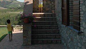 Un bâtiment en pierre avec un escalier menant à un balcon.