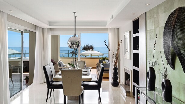 A modern dining area with a view of the sea, a large mirror, and contemporary decor. - Apt 401 Luxury Serv Aparts-Estepona, 3 Bed, Heated 20m Pool, Jacuzzi - an Oasis (Estepona)