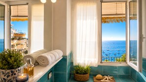 A balcony with a view of the sea, a towel rack, a candle, and a small plant. - AMORE RENTALS - Casa Raffi with Sea View on Positano’s Spiaggia Grande (Positano)