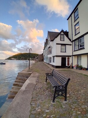 A cobblestone waterfront promenade with a bench, a row of traditional houses, and boats on the water. - COMFORTABLE COUNTRY CHALET, NEAR DARTMOUTH, DEVON (Dartmouth)