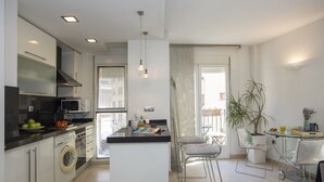 A modern kitchen with a central island, built-in appliances, and a dining area with bar stools. - Singular Stays Poeta Querol (València)