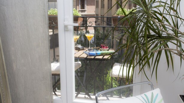 A balcony with a table, chairs, and a potted plant. - Singular Stays Poeta Querol (València)