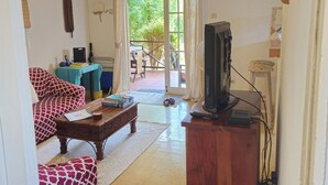 A living room with a sofa, coffee table, and television.