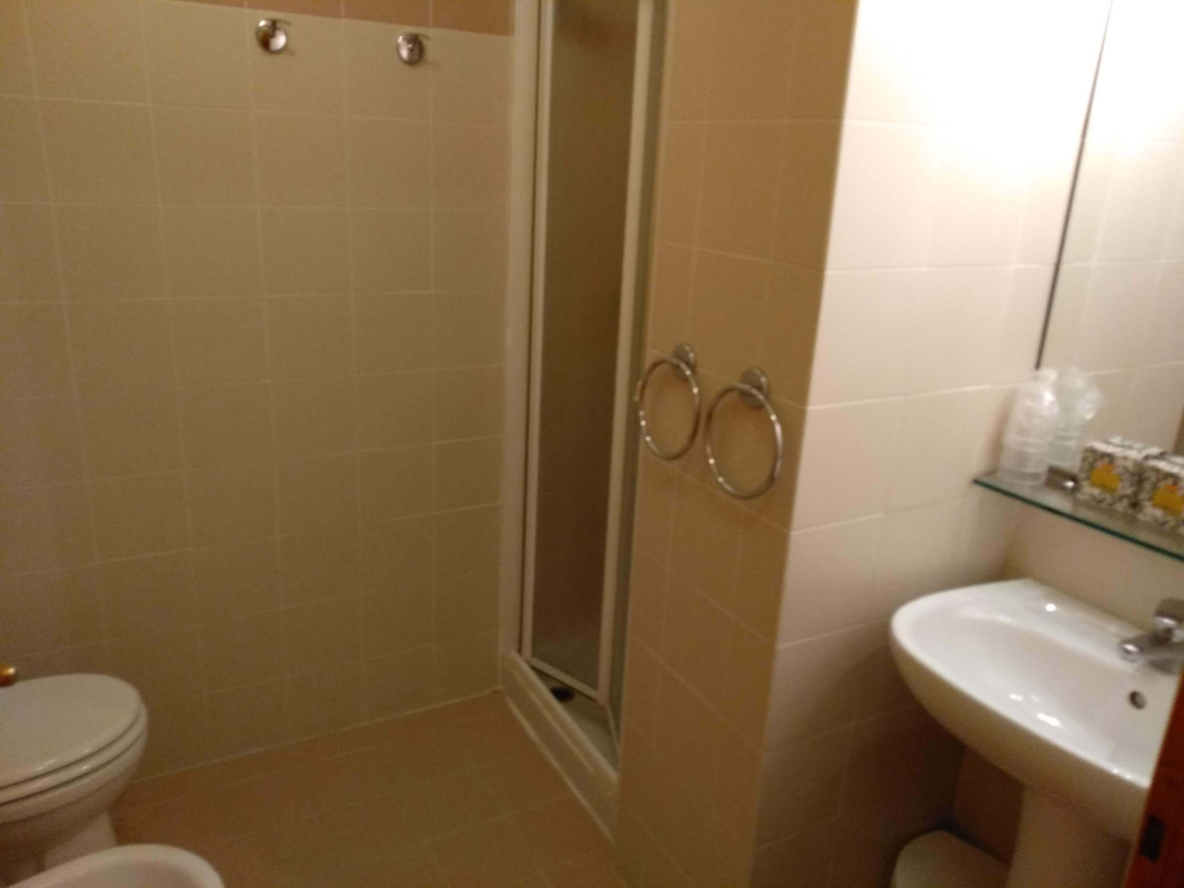 Ein Badezimmer mit Toilette, Waschbecken und einer Duschkabine aus Glas.