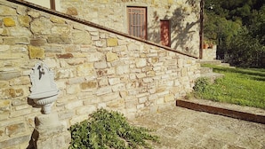 A stone building with a rustic appearance, featuring a small window and a decorative stone fixture on the wall.