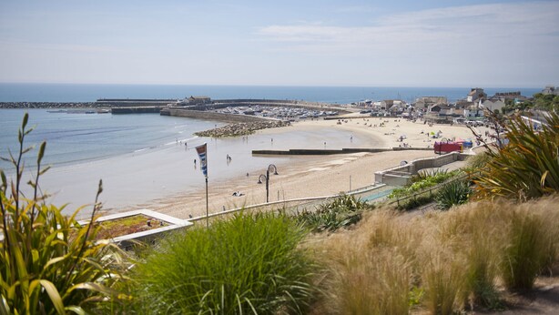 A coastal beach with a sandy shore, a rocky breakwater, and a clear blue sky. - Lavender Cottage - sleeps 4 guests  in 2 bedrooms (Lyme Regis)