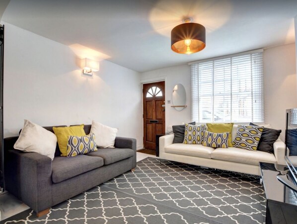 A living room with two sofas, patterned rugs, and a ceiling light fixture. - Fully equipped city centre modern townhouse - 5 star rating. (Brighton)