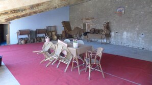 Une pièce au décor rustique, avec un tapis rouge, des meubles en osier et divers paniers et récipients.