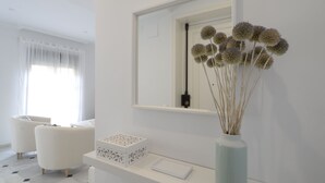 A modern bathroom with a white vanity, a mirror, and a vase with dried flowers. - Among magnolias, in the heart of the city ... (Córdoba)
