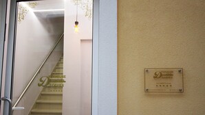 A staircase with a handrail and a wall-mounted sign.