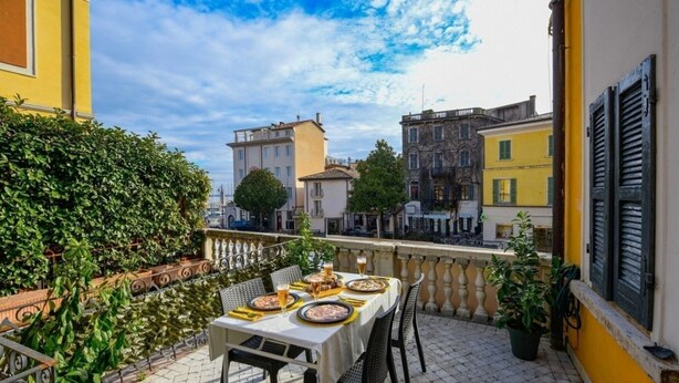Eine Terrasse mit gedecktem Tisch für zwei Personen mit Blick auf eine Stadtlandschaft und historischen Gebäuden.