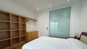 A bedroom with a bed, wooden wardrobe, and a sliding glass door closet. - Agi Peater 3A Apartamento for rent in Roses Girona. (Roses)