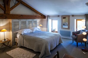 A bedroom with a large bed, wooden beams, a chair, and a lamp. - Refined property 7 Bedr (7/17 p) on private 80 acres Heated Pool Pond and Horses (Mareuil)