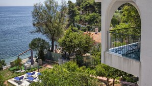 A seaside property with a balcony overlooking the sea, a garden with various plants, and outdoor seating. - VILLA BUONASERA ON THE SEA (Santa Flavia)