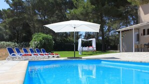 A swimming pool with lounge chairs and a canopy. - Cottage `Es Pinaró` (Manacor)
