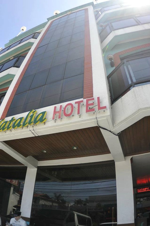 Um hotel chamado "Catalina Hotel", com fachada moderna, janelas grandes e entrada visível.