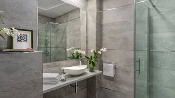 Een bad/douchecombinatie, handdoeken, toiletpapier