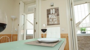 Un coin repas avec une table dressée pour deux personnes, un mur orné d’une citation inspirante et une vue sur l’extérieur par une fenêtre.