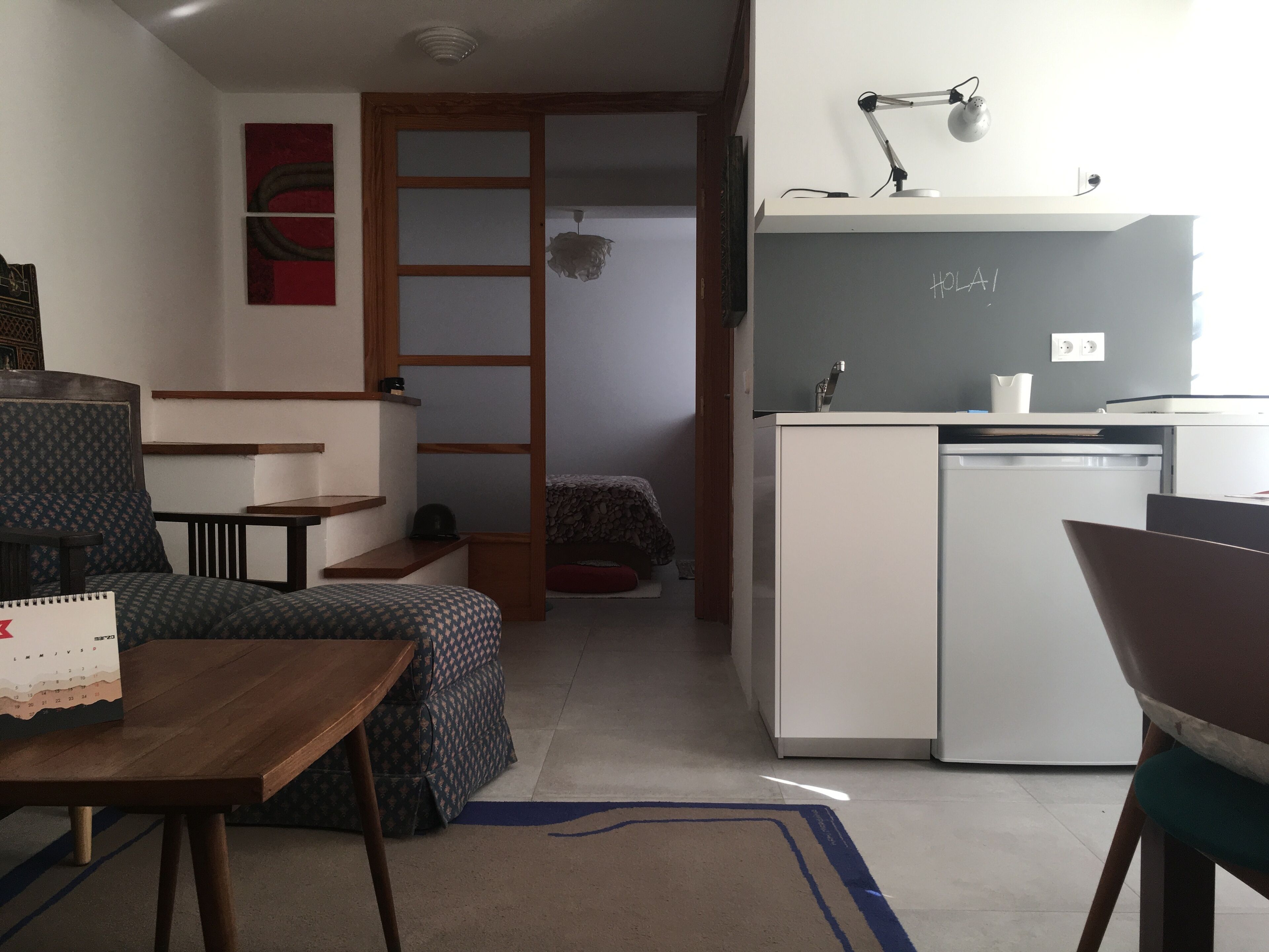 Un espace de vie compact comprenant un coin cuisine, un coin repas et un petit coin salon.