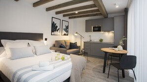 Une chambre d’hôtel moderne équipée d’un lit, d’une table de chevet et d’une petite kitchenette.