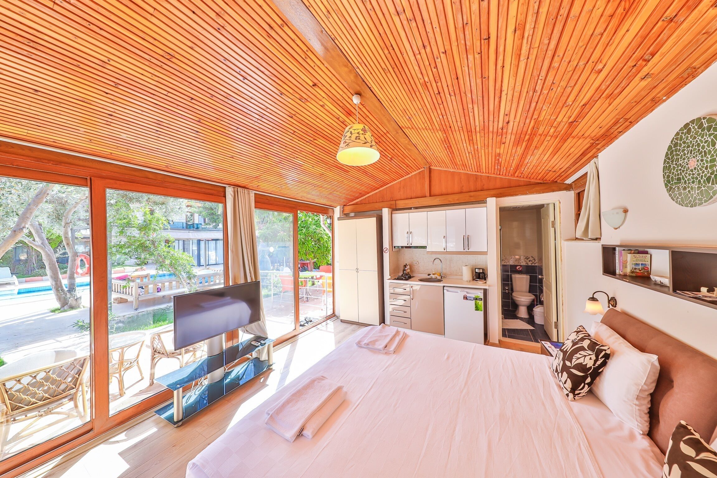 Une chambre d’hôtel avec un grand lit, une télévision, un bureau et une vue sur l’extérieur.