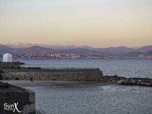 A coastal view with a stone wall, a white dome structure, and a distant cityscape. - Charming 3-bed, 3-bath house in old Antibes with terrace & aircon. Parking close (Antibes)