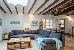 A living room with a sectional sofa, a coffee table, and a dining area with a table and chairs.