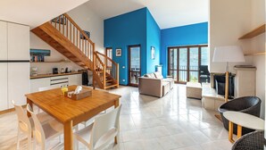 A modern interior with a wooden staircase, a dining area, a living room with a sofa, and a kitchen area. - Balcone di Noa e Stella, Menaggio, Italy (Menaggio)