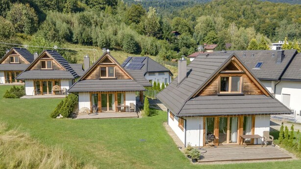 Eine Reihe moderner Häuser mit zwei Etagen, schrägen Dächern, großen Fenstern und Holzbalkonen.
