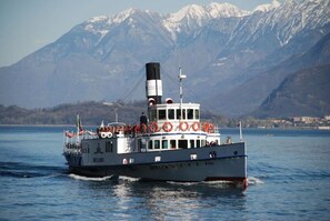 Een boot met drijvers op het dek, een kajuit en een bergachtige achtergrond.