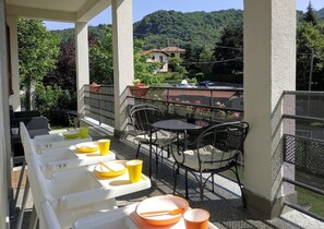 Een balkon met buitenmeubilair, een tafel en stoelen.