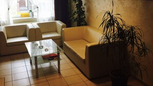 A living room with a sofa, a coffee table, and a potted plant. - Albero (Swinoujscie)