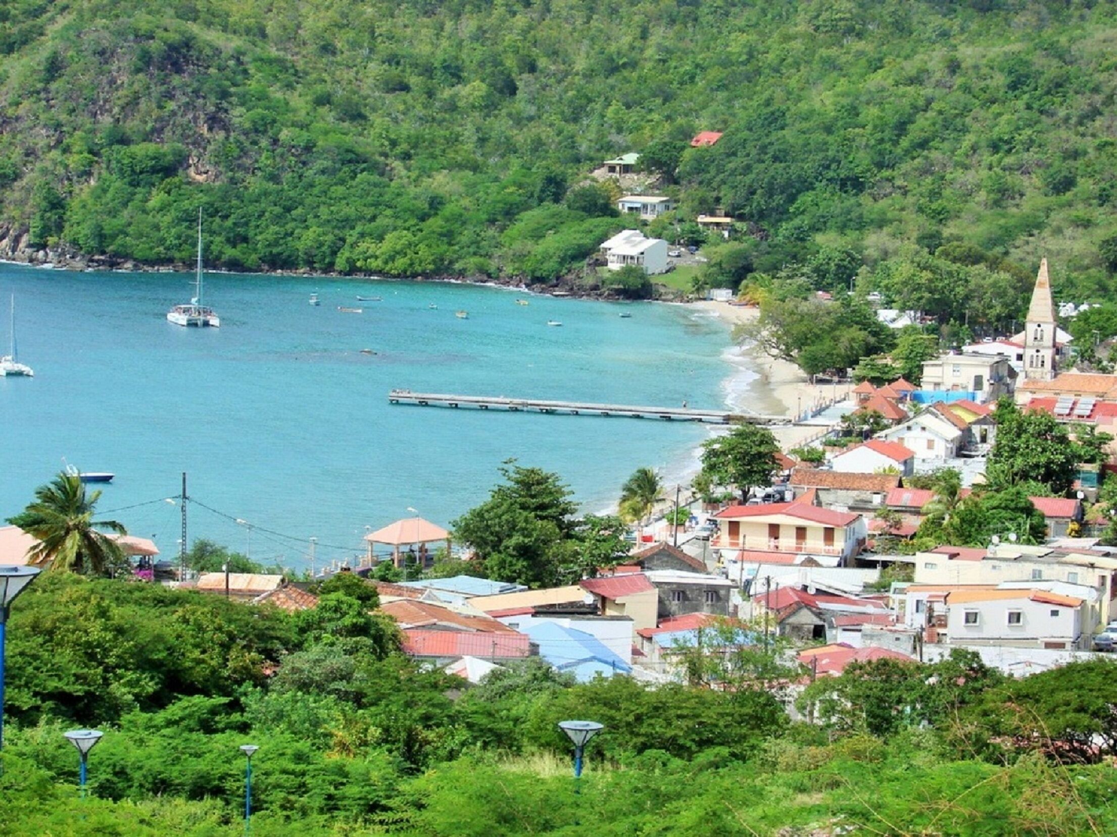 A coastal town with buildings, a pier, and boats on the water.