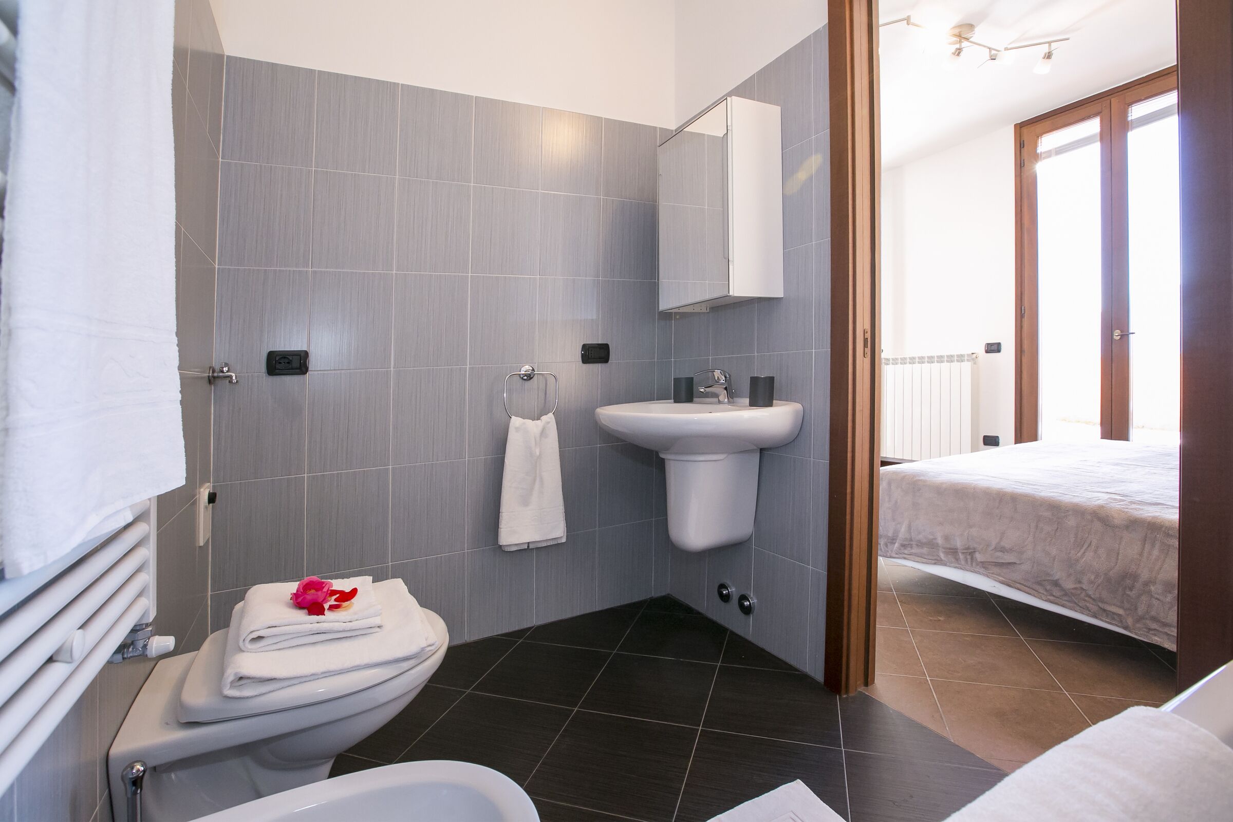 Ein modernes Badezimmer mit Toilette, Waschbecken und Duschbereich.