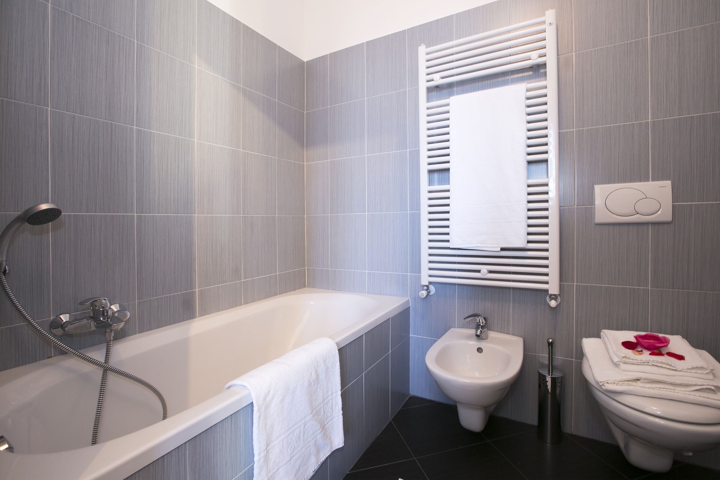 A modern bathroom with a bathtub, bidet, and toilet.