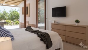 A modern bedroom with a bed, a TV, a dresser, and a view of the outdoors. - Can Ribas - Spectacular villa with pool near Palma (Marratxi)