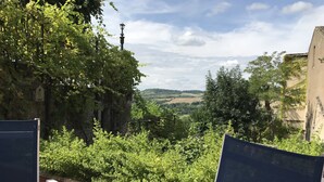 Une terrasse avec une table et des chaises donnant sur un paysage pittoresque.