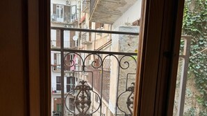 A balcony with a wrought iron railing, a view of a street with parked cars, and buildings with balconies. - Convenient and cozy apartment in the heart of the city nearby historic center (Palermo)